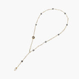 Y-shaped gold-plated necklace with white and gray freshwater pearls on cream background, showing adjustable drop design.