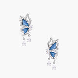 Silver butterfly earrings with blue denim fabric wings and dangling teardrop crystals on cream background
