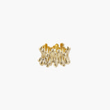 Gold-plated brass ring with sculptural petal-like elements in a wide band design on beige background