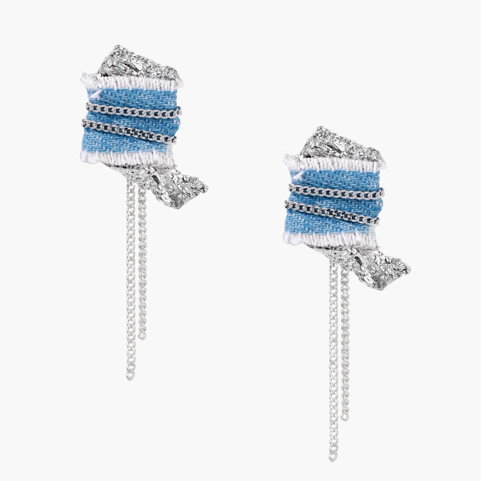 Blue denim fabric earrings with white fringe, silver chains, metallic accents, and dangling chain tassels on cream background.
