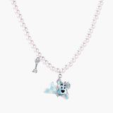 Pearl necklace with playful blue dog pendant accented with sparkly crystals on cream background.