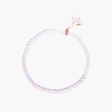 Double-wrap lavender beaded bracelet with rose quartz, pearls, gold vermeil charm and pink tassel on white background.