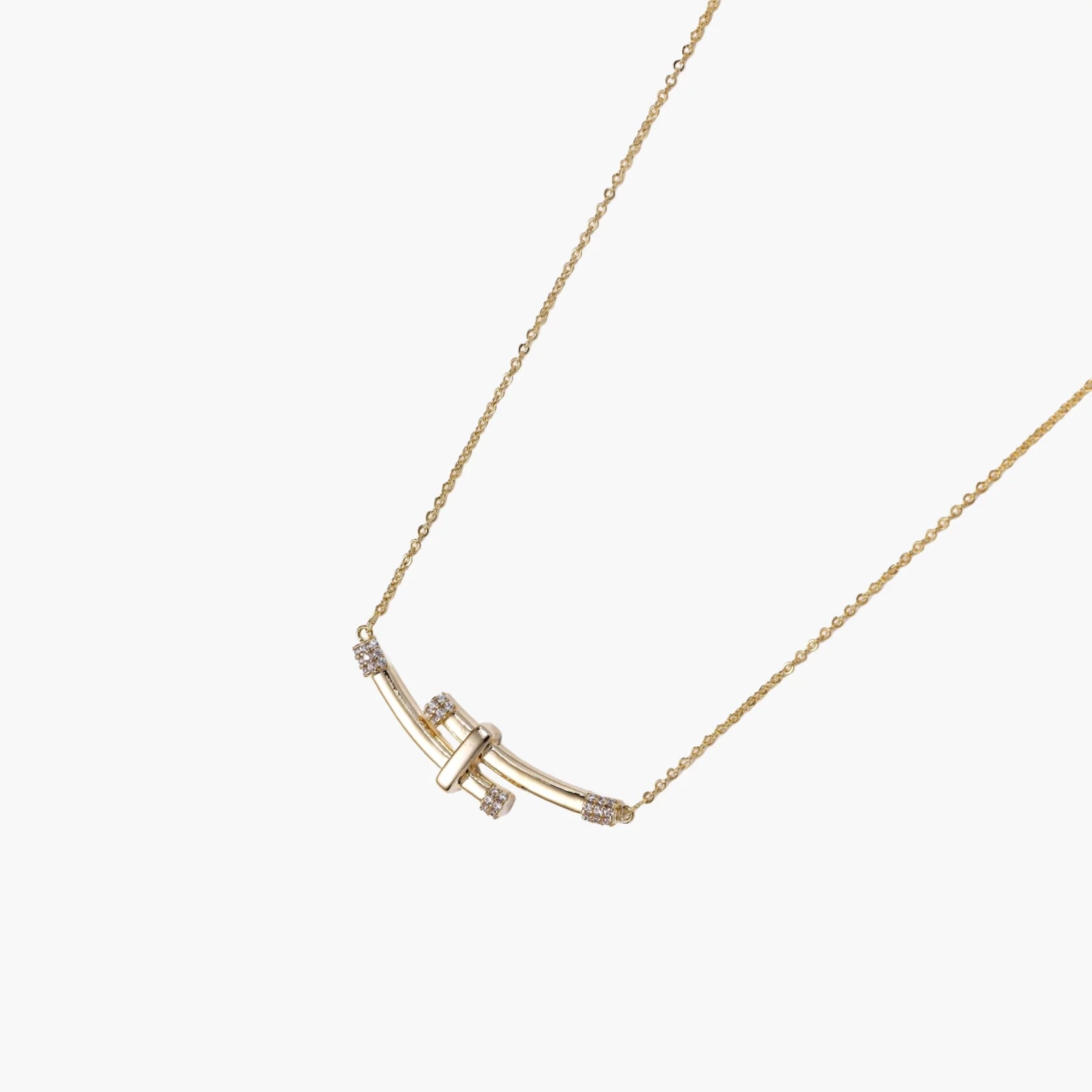 Gold-plated curved bar necklace with diamond accents on delicate chain against cream background