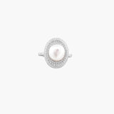 Silver ring with lustrous white pearl center surrounded by sparkling crystal halo on light background.