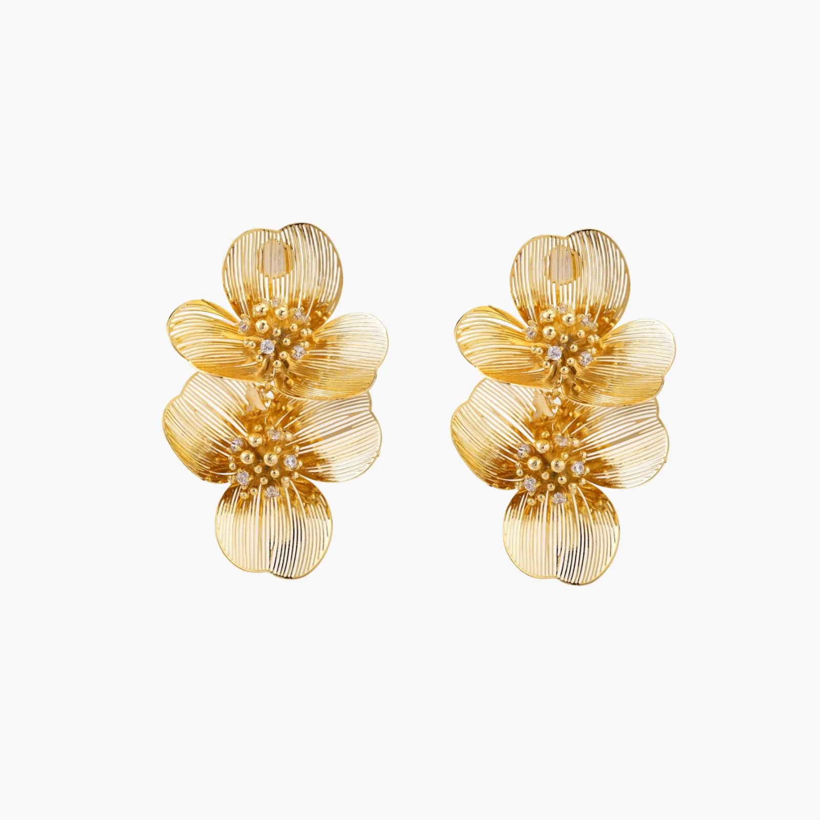 Pair of gold-plated double flower earrings with textured petals and crystal centers on cream background.