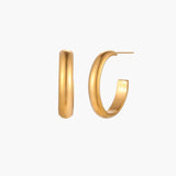 Chunky brushed gold hoop earrings in 14K plated stainless steel on cream background, front and side view.