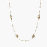 Long gold chain necklace with baroque pearls wrapped in leaf designs and small freshwater pearls spaced along the strand
