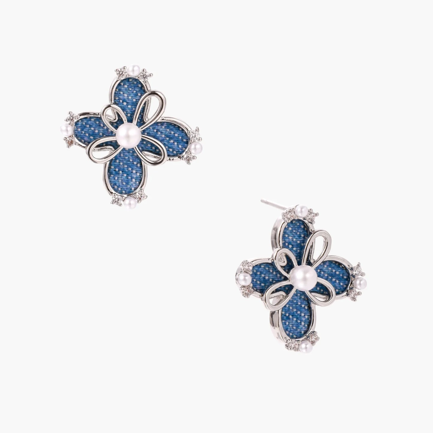 Blue denim fabric flower studs with white gold plated petals, pearl center, and zirconia accents on white background