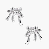 Sculptural bow earrings in polished white gold plate with sparkling zirconia stones and flowing ribbon details