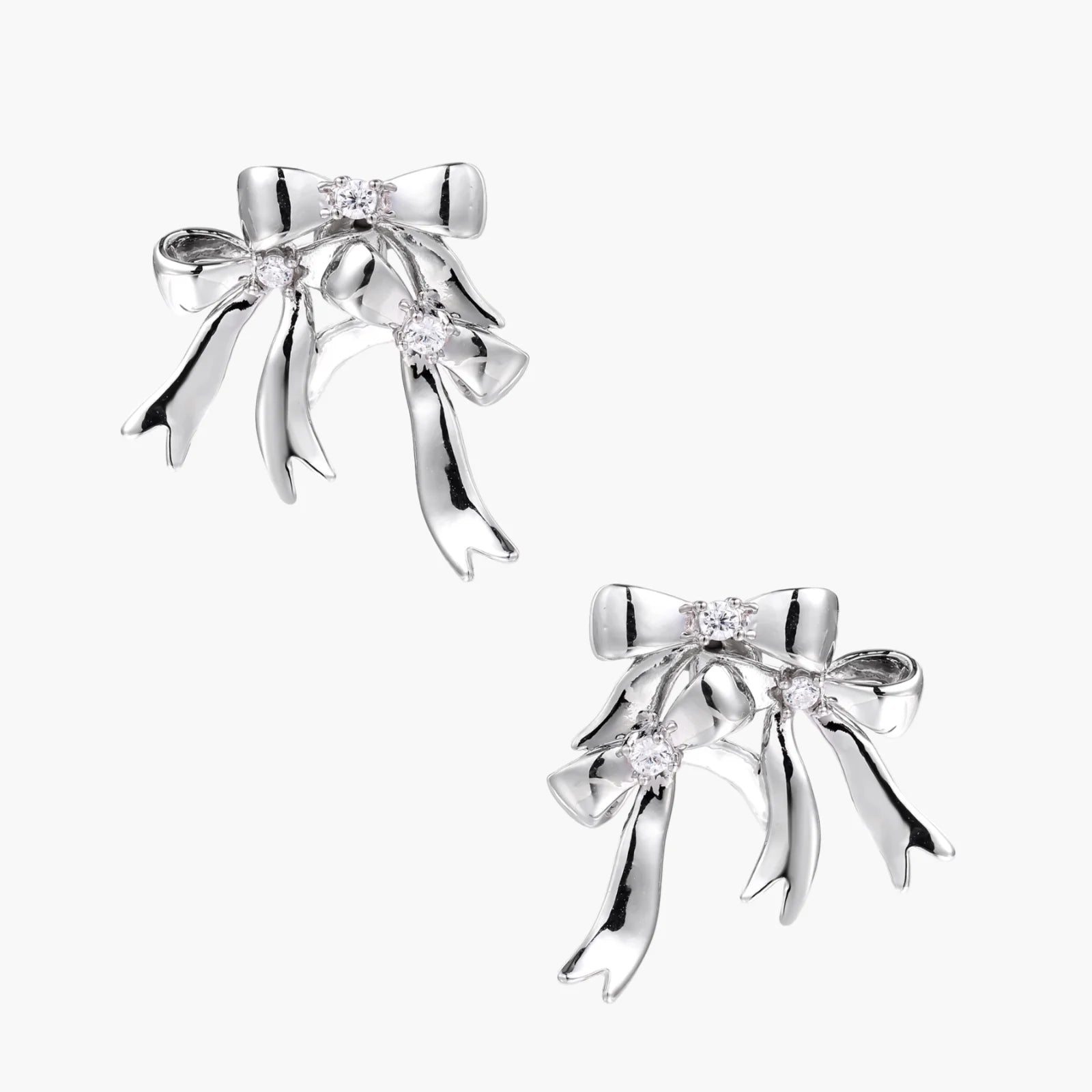 Sculptural bow earrings in polished white gold plate with sparkling zirconia stones and flowing ribbon details