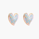 Heart-shaped stud earrings with swirled turquoise and pink enamel in gold-plated frames on cream background
