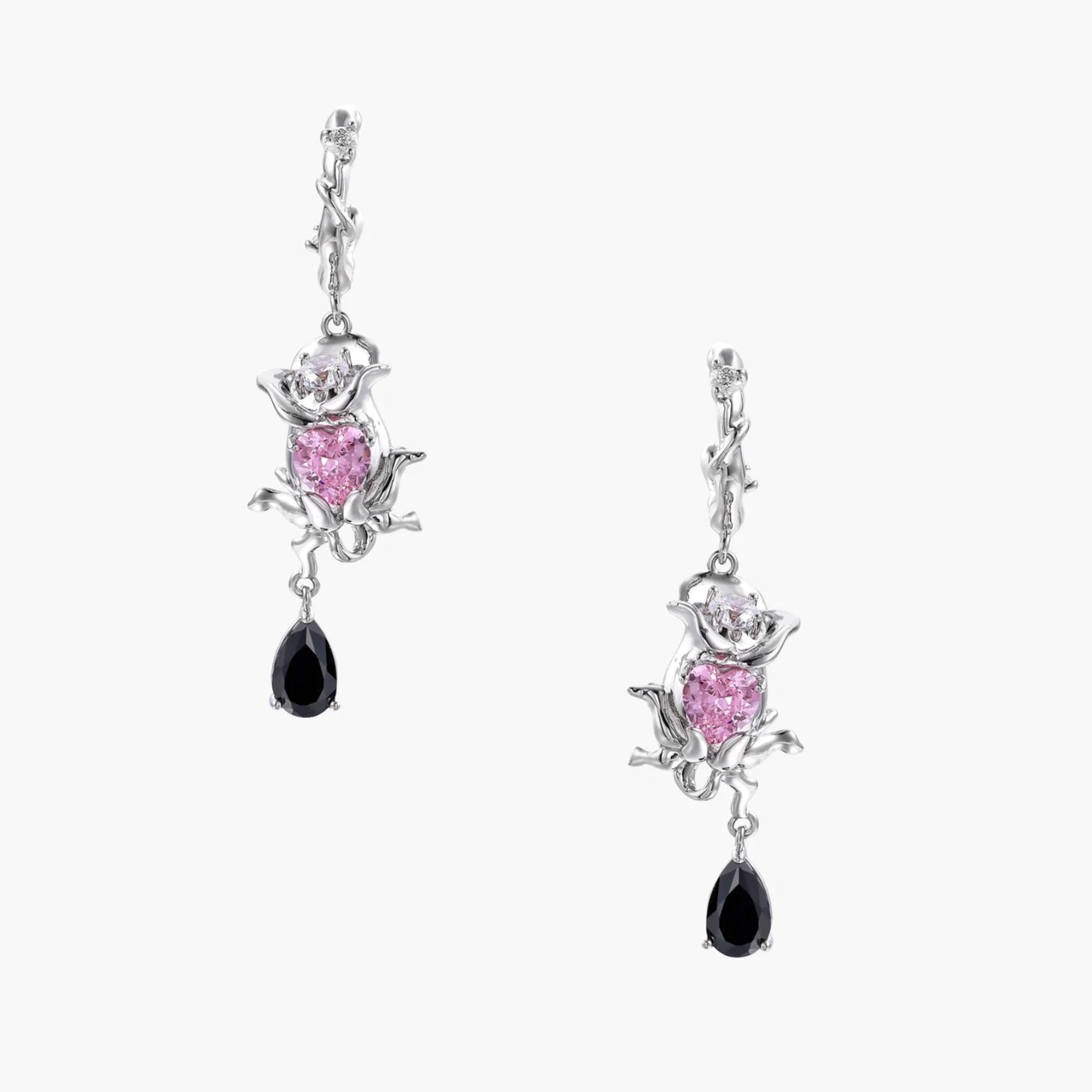 Silver-toned drop earrings with ornate rose design, pink zirconia center, and black teardrop stones on cream background