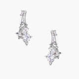 White gold-plated huggie earrings with geometric emerald-cut zirconia clusters in starburst formation on beige background