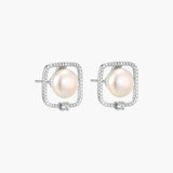 Rhodium-plated silver stud earrings with cushion frame, centered freshwater pearl, and tiny crystal accent