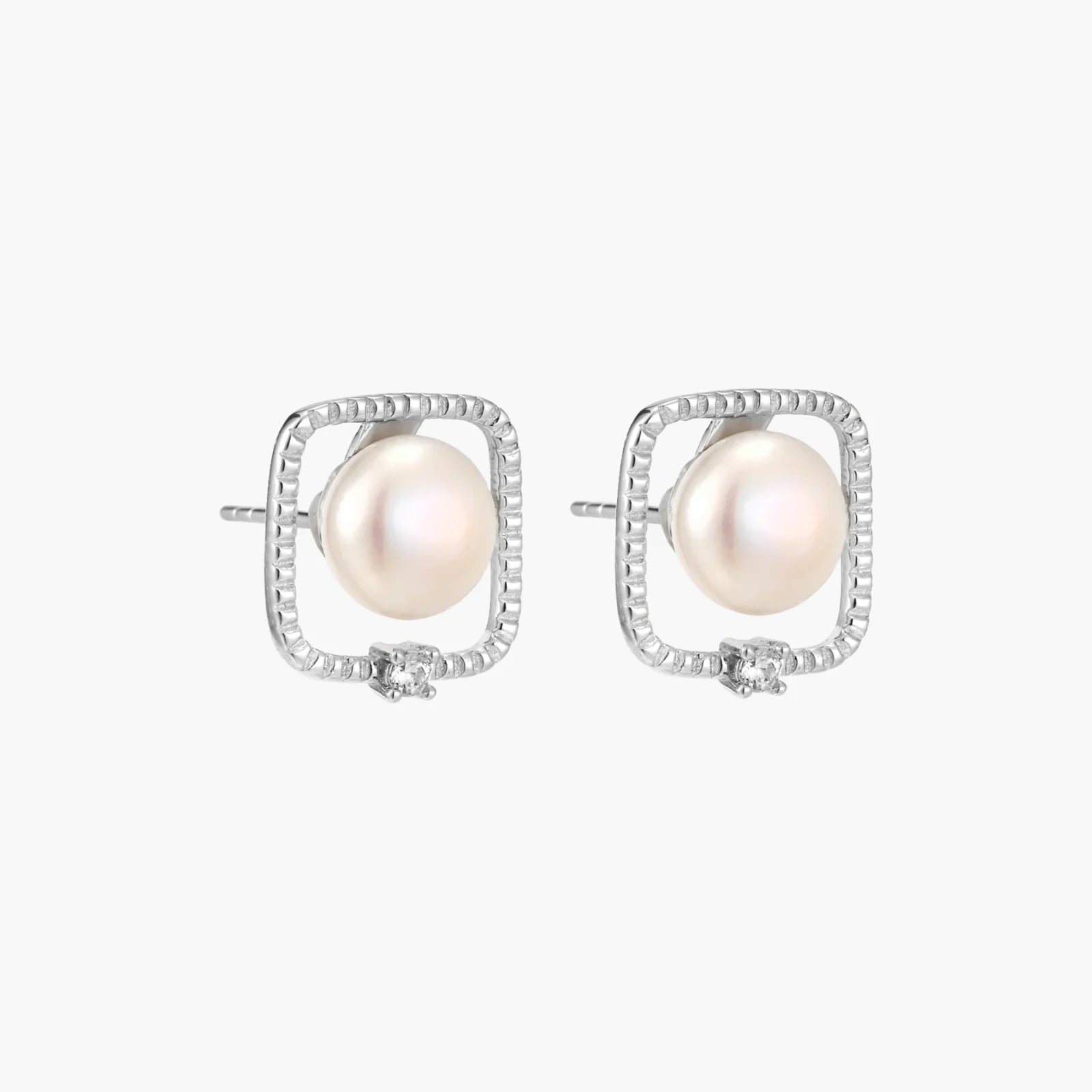 Rhodium-plated silver stud earrings with cushion frame, centered freshwater pearl, and tiny crystal accent