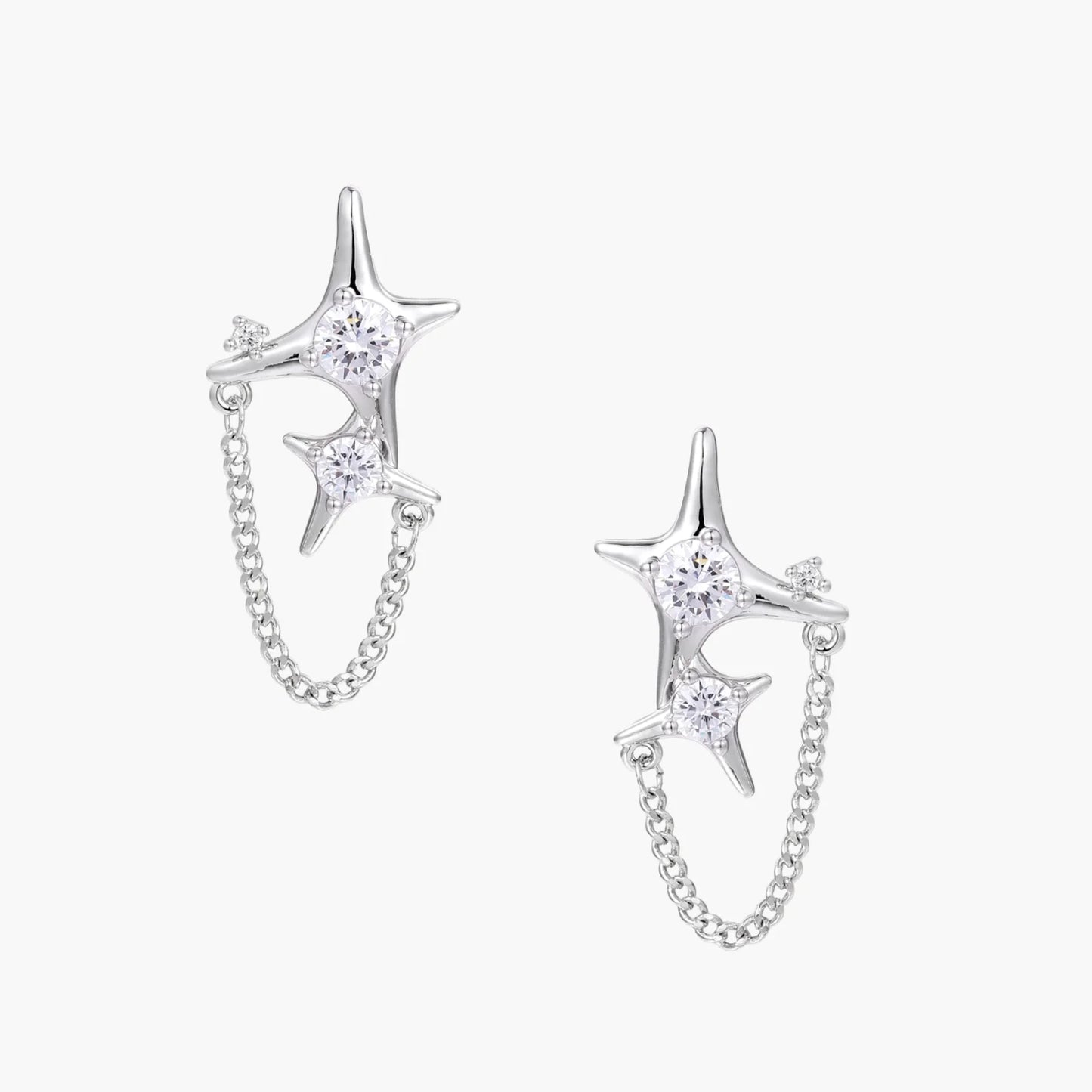 Silver star studs with crescent moon cutouts and zirconia stones connected by delicate chains on white background