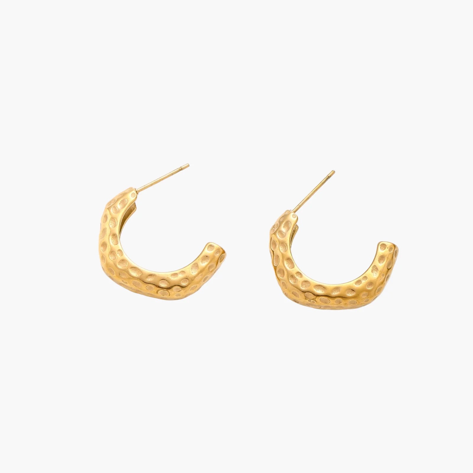 Gold-toned hoop earrings with hammered dimpled texture and post closure on cream background