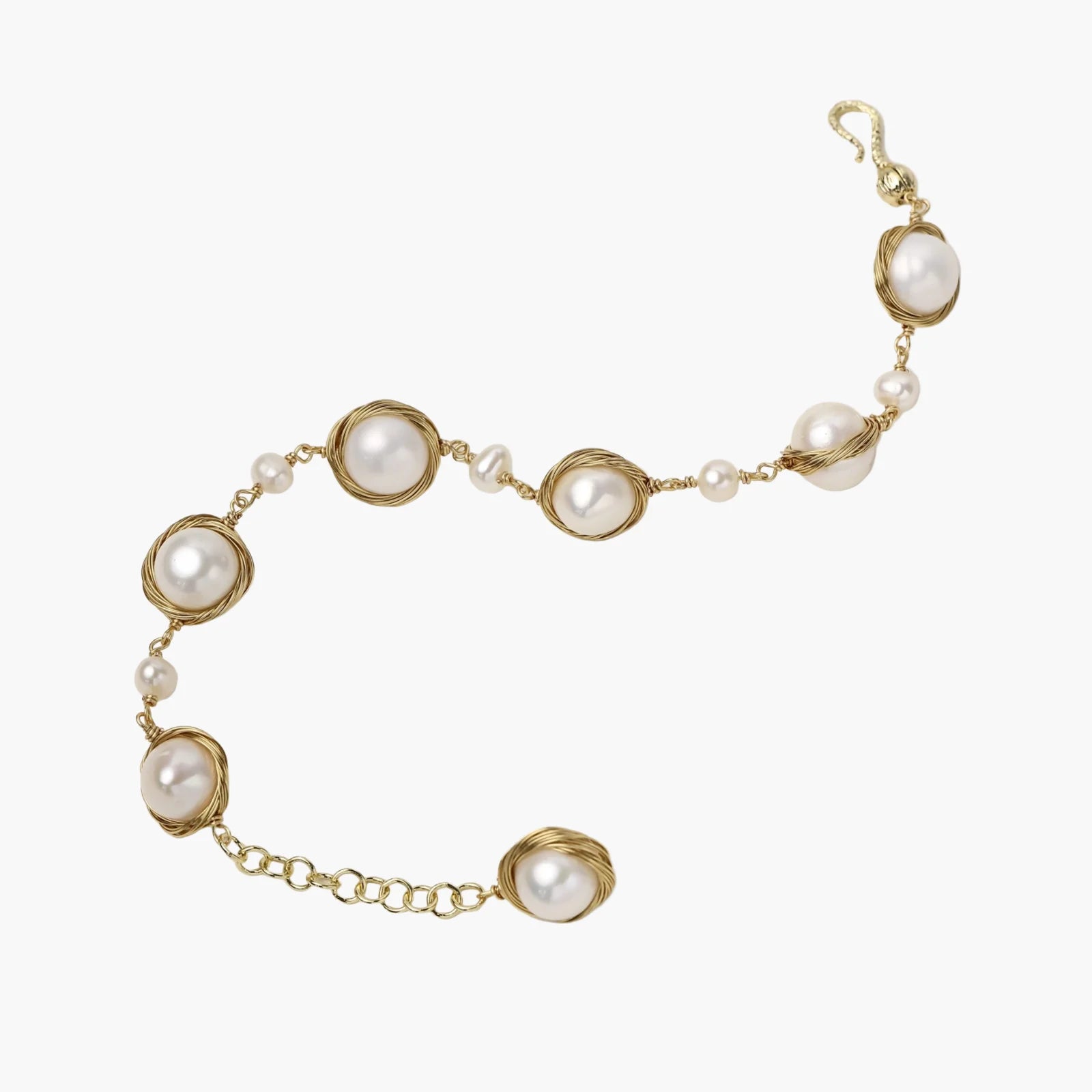 Gold wire-wrapped freshwater pearl bracelet with alternating pearl sizes on cream background, adjustable length