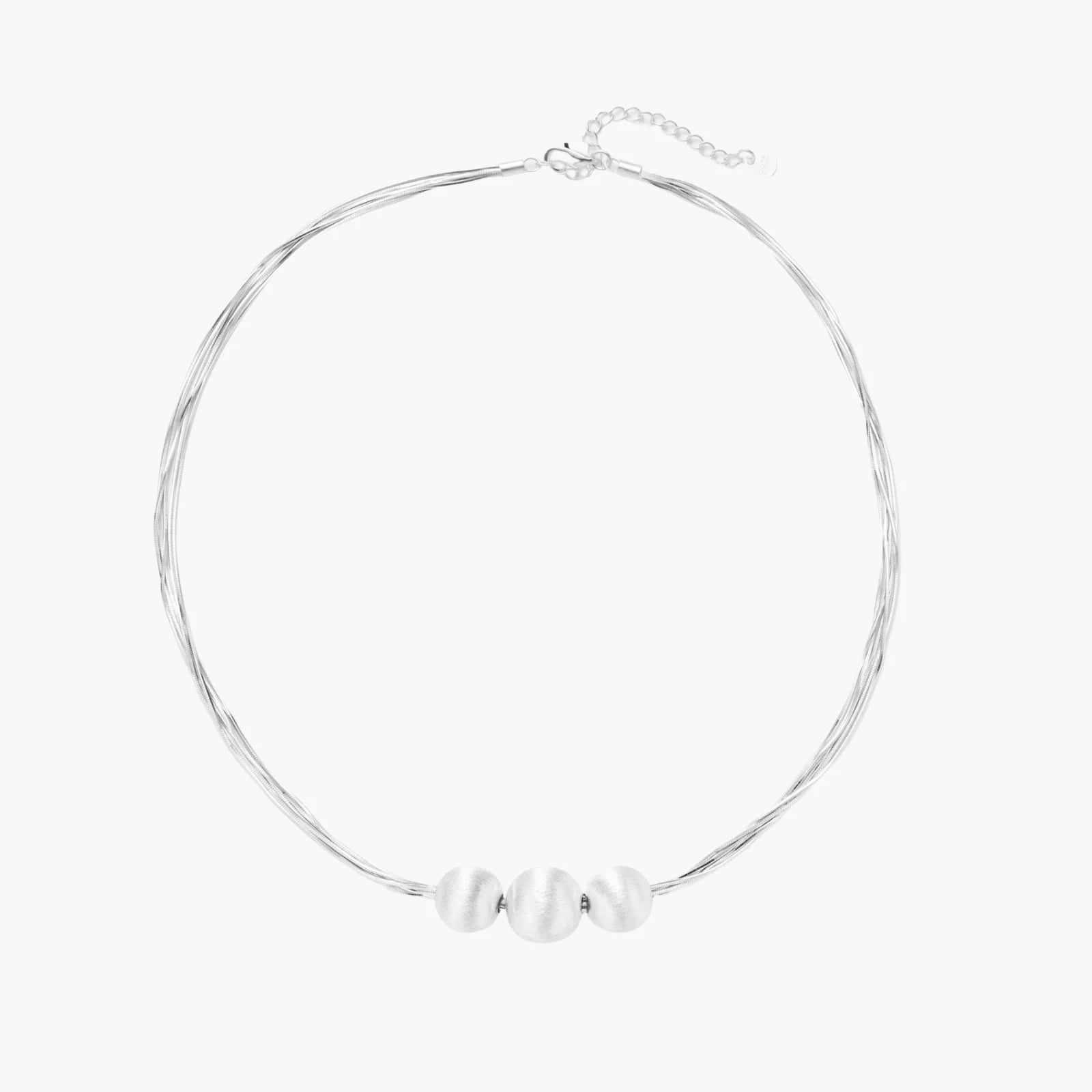 Sterling silver multi-strand necklace with three brushed round beads on cream background