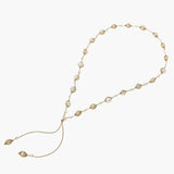 Adjustable gold lariat necklace with freshwater pearls nested in delicate cage settings and Y-shaped tassel drop