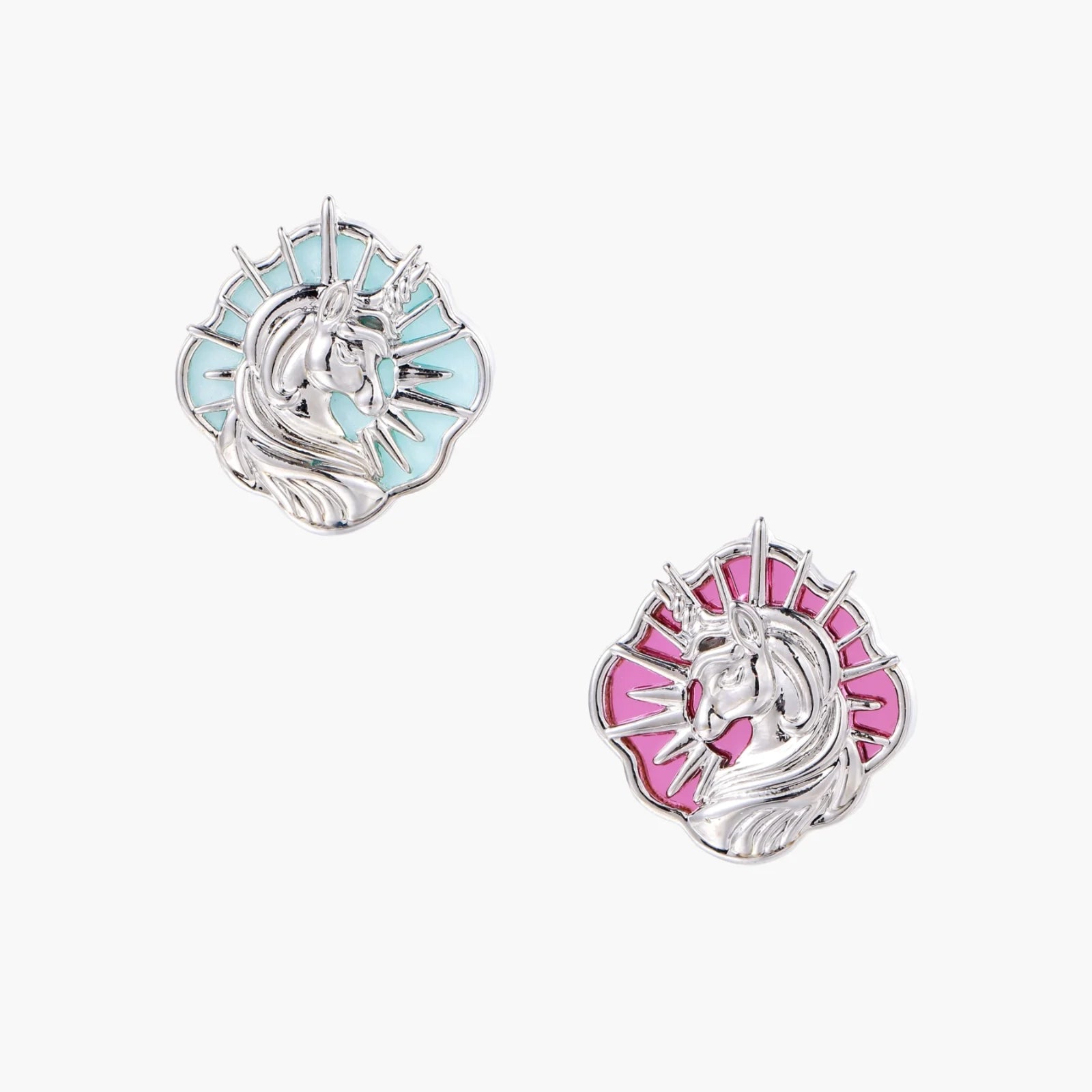 Silver unicorn stud earrings with pastel blue and pink enamel stones in sunburst prong settings on cream background