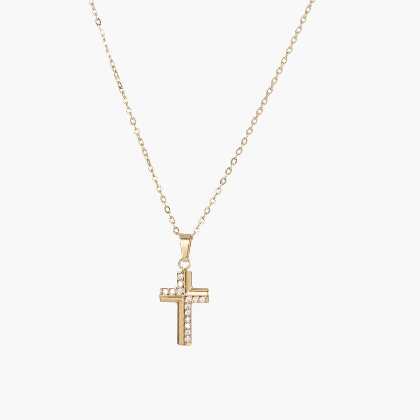 Delicate 14K gold-plated cross pendant with crystal accents on fine chain against cream background