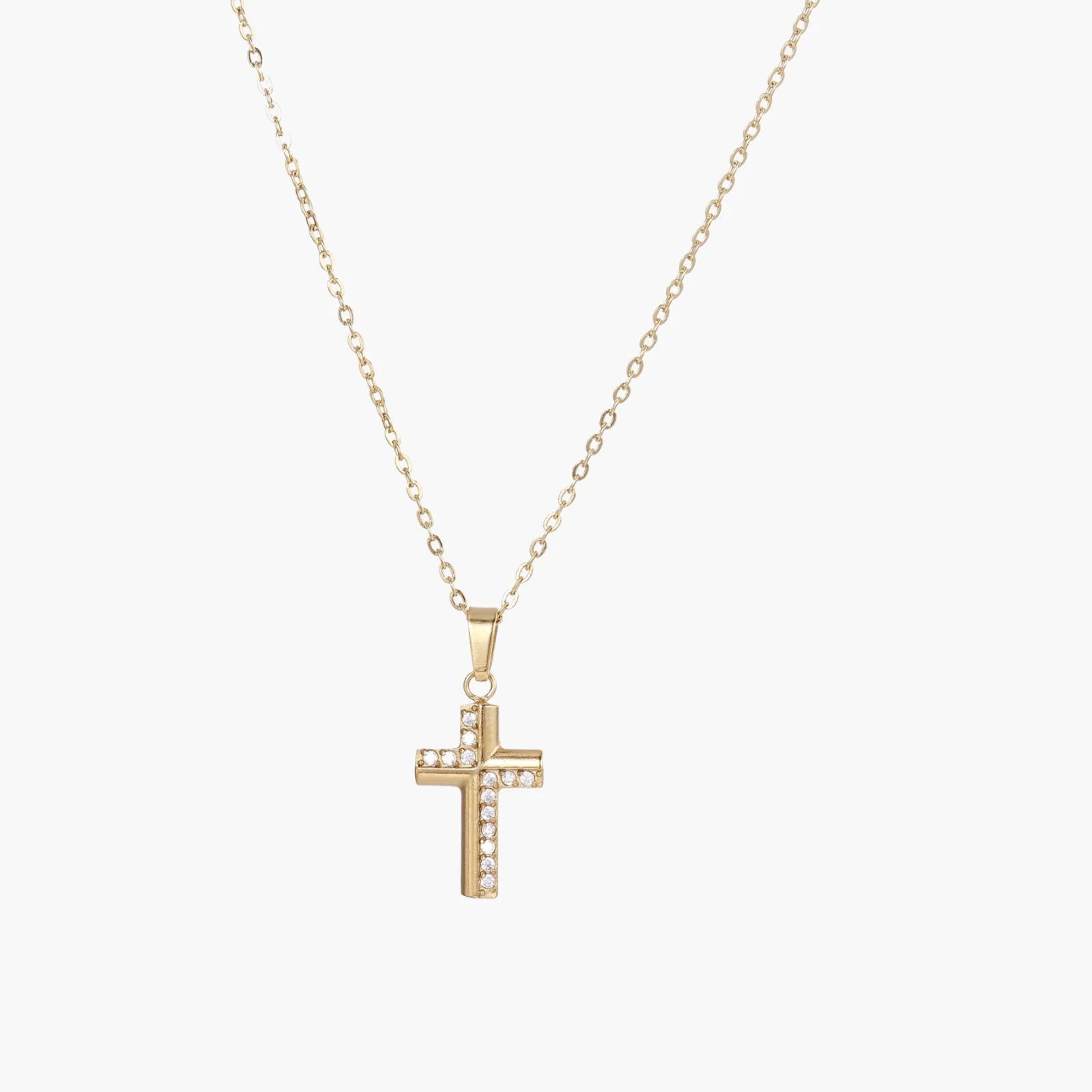 Delicate 14K gold-plated cross pendant with crystal accents on fine chain against cream background