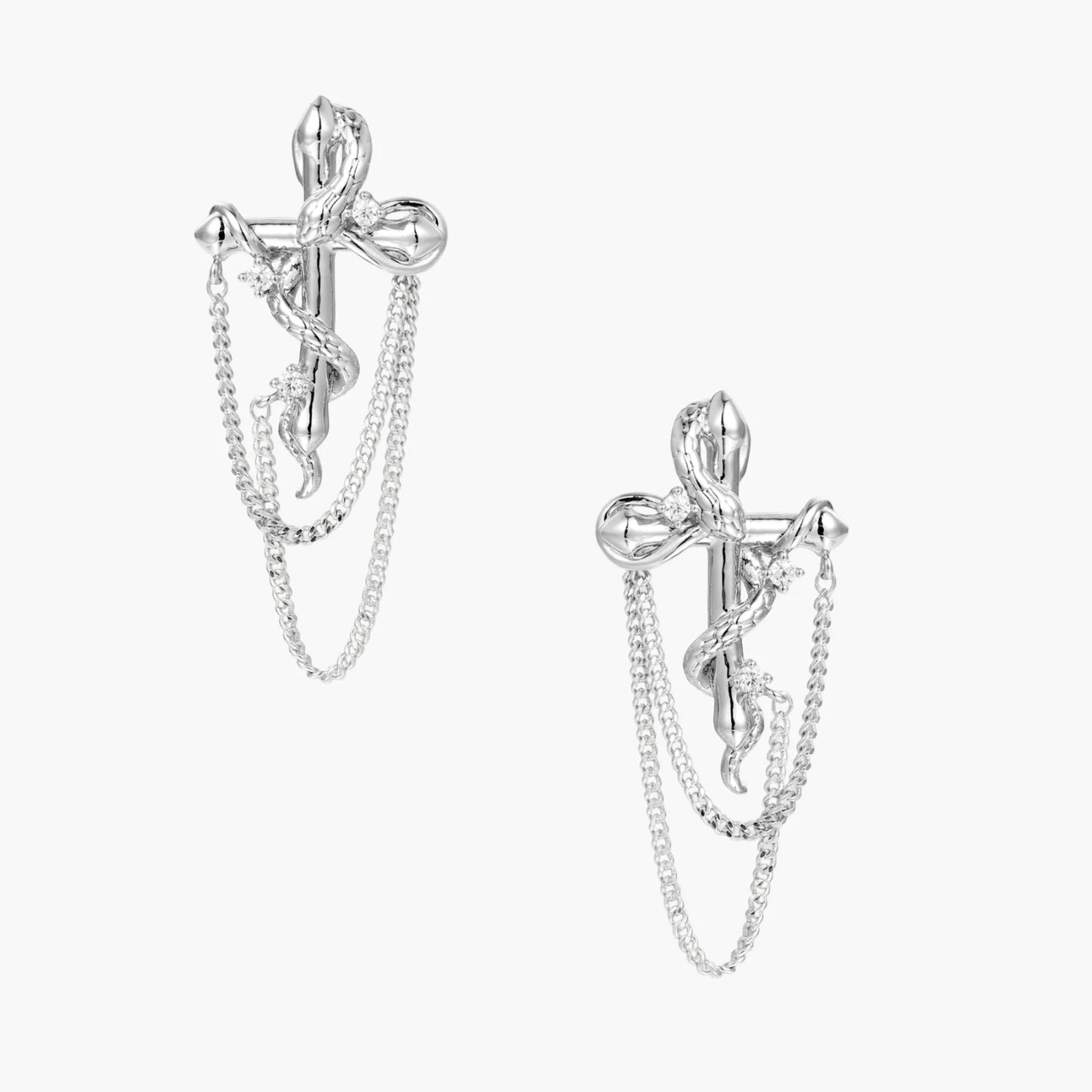 Sculptural white gold bow earrings with cascading chain details on neutral background