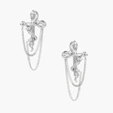 Sculptural white gold bow earrings with cascading chain details on neutral background