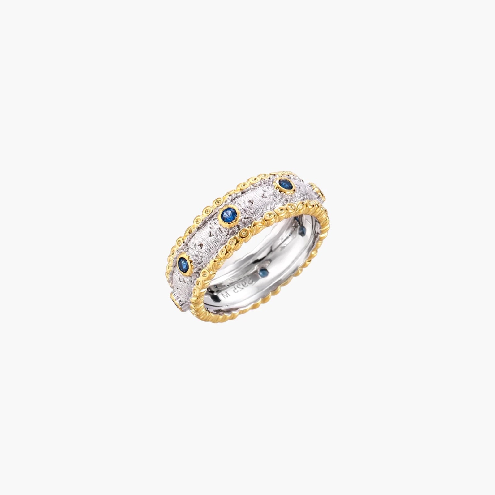 Two-tone ring with brushed silver center, gold beaded edges, and blue zirconia stones on white background.